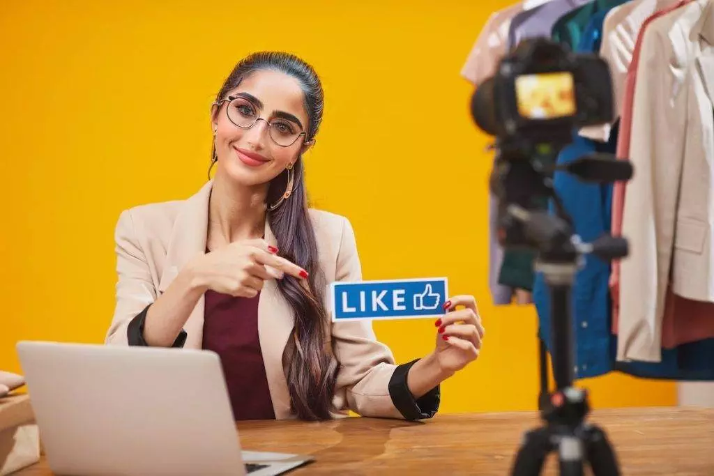 a social media influencer holds up a like buttons