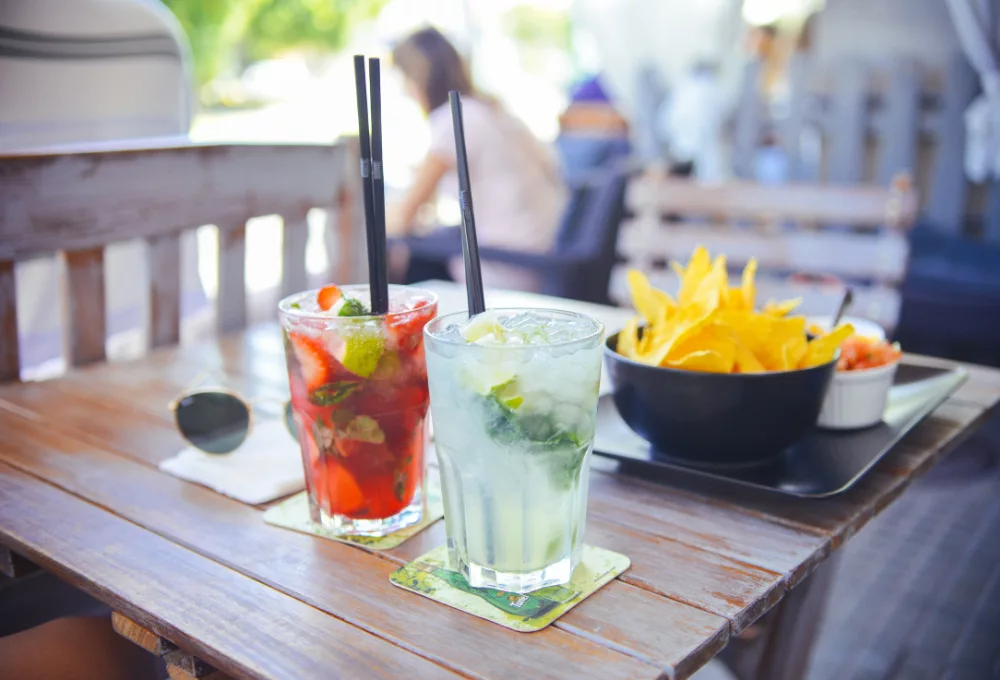 Refreshing summer cocktails with lime and mint on an outdoor table next to a bowl of tortilla chips