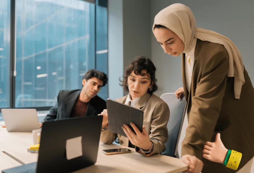 Diverse business team collaborating on a project using a tablet in a modern office.