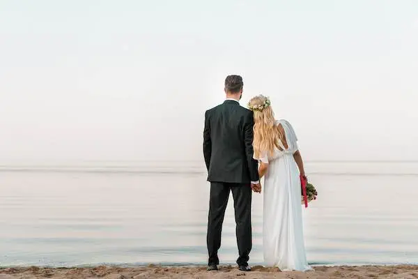 back-view-of-wedding-couple-standing-on-beach-with-2022-01-18-23-38-55-utc (1)