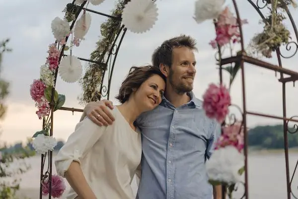 happy-couple-embracing-under-wedding-arch-2022-03-08-01-23-42-utc (1)