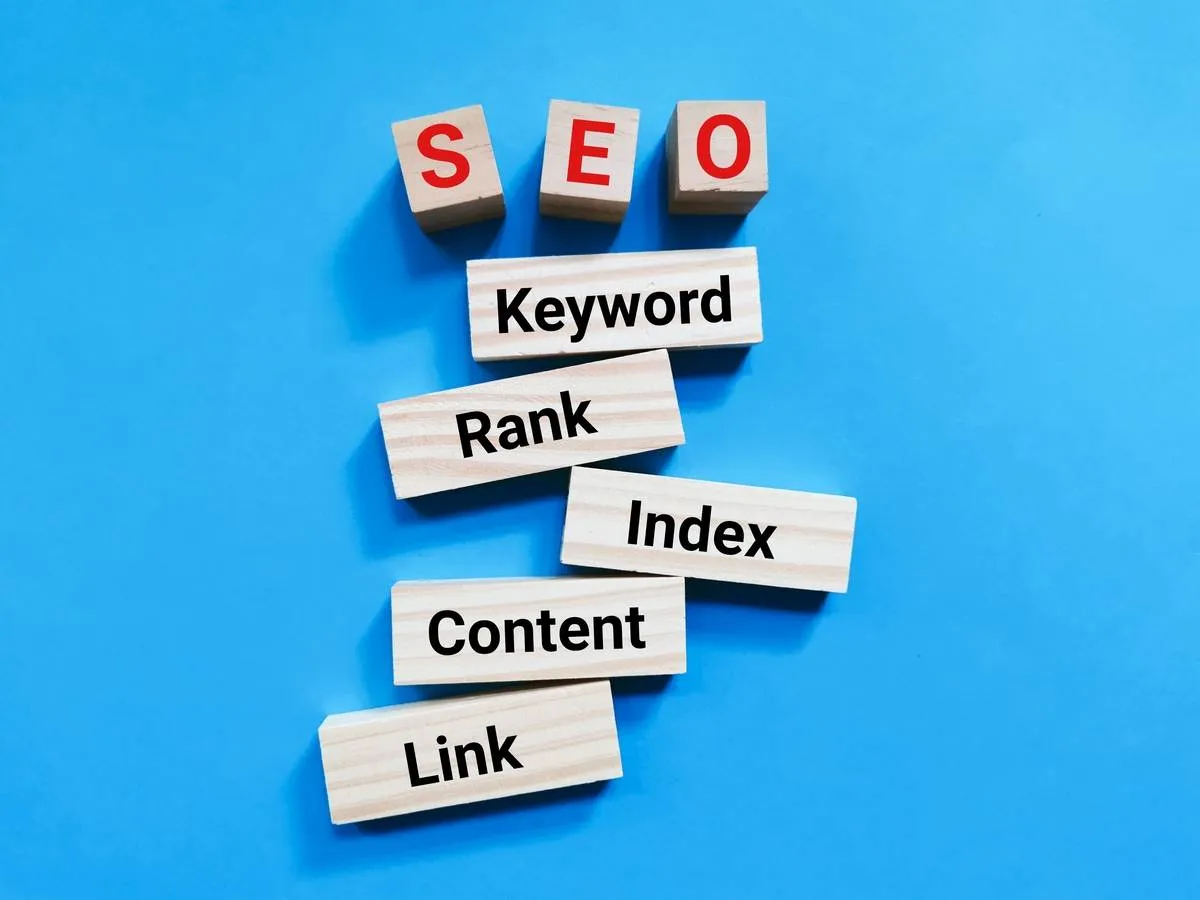 SEO process on wooden blocks with keywords, rank, index, content, and link on a blue background