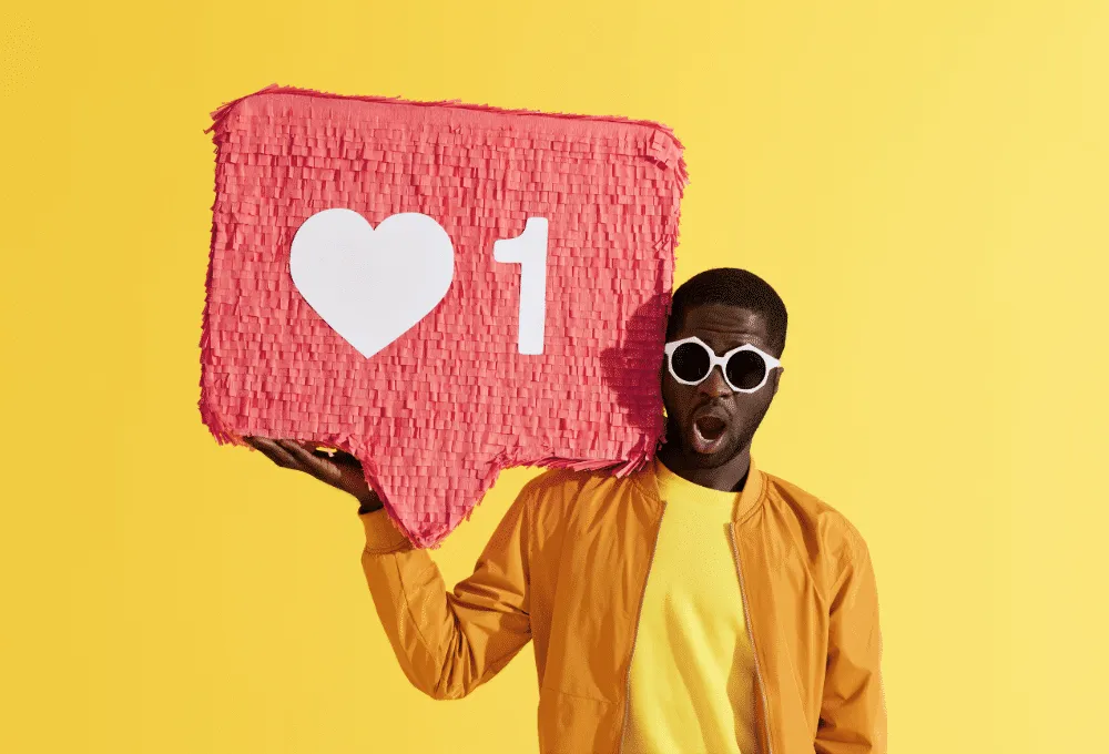 Man holding large social media like icon with heart on yellow background